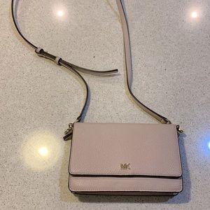 Michael Kors small crossbody bag in a light pink/beige color.